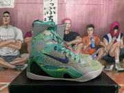 Side view of a green patterned basketball sneaker with a dark blue Nike swoosh, mesh-like upper, and light outsole.