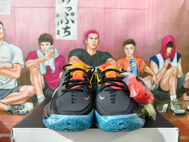 Pair of black basketball shoes viewed from the front, with orange accents and translucent blue outsoles.