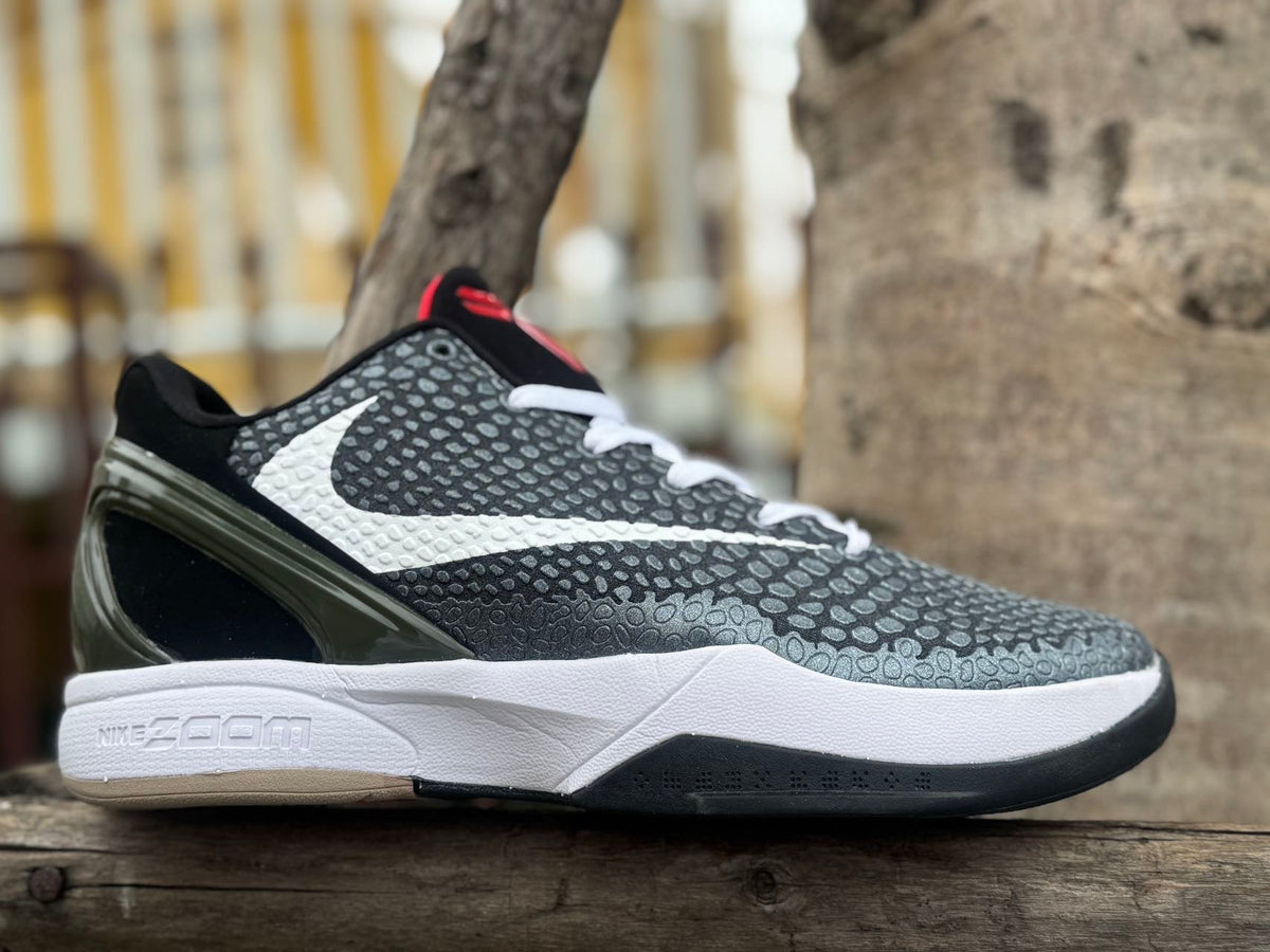 Side view of black and white Nike Kobe 6 basketball shoe with red accents