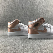 Close side view of the pair highlighting the rose-gold Swoosh and ankle panels.