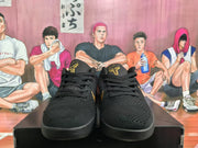 Front view of black lace-up basketball sneakers with gold Kobe tongue logos.