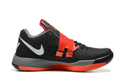 Side view of a black Nike KD 4 shoe with a red strap and gray midsole.
