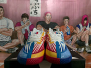 Front view of mismatched Converse sneakers showing white laces, colorful striped uppers and contrasting blue and red toe sections.