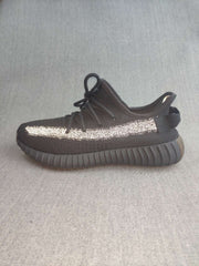 Side profile of a single black sneaker with a reflective stripe, padded collar, and thick ribbed outsole.