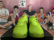 Front view of vivid green Nike basketball shoes with textured uppers and green laces.