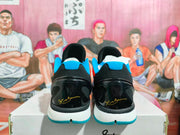 Rear view of blue, black, and white Nike basketball sneakers showing glossy black heel panels and blue outsole accents.