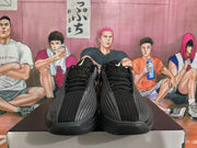Front view of black Nike basketball sneakers with black laces, ribbed toe panels, and light-colored tongue branding.