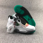 Angled view showing the white upper, multicolor mesh panels, black laces, grey speckled midsole, and green outsole.