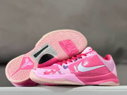 Pink Kobe 5 shoe beside an upturned outsole showing the tread pattern