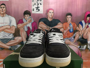 Front view of black low-top sneakers with white laces, white midsoles, and cream-colored outsoles.