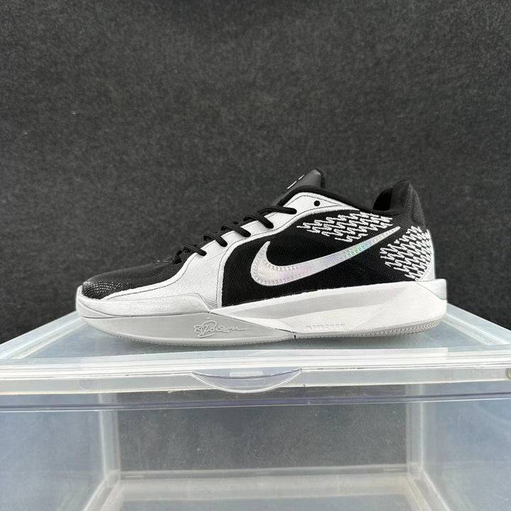 Side view of a low-cut Nike Sabrina basketball shoe in grey, silver, black, and white.