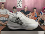 Side profile of a white Nike basketball sneaker with silver-gray panels, black Swoosh detailing, and ZoomX branding.