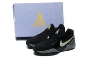 The sneakers displayed in front of a Jordan-branded shoe box, showing the black, gray, white, and yellow color scheme.