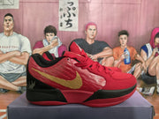 Side profile of a red low-top sneaker with gold swoosh-style branding and a black-and-red outsole.