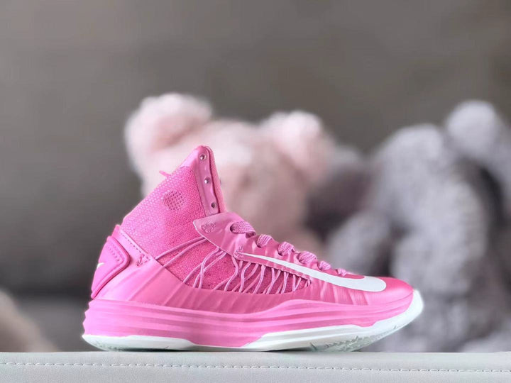 Side view of a pink high-top kids' basketball shoe with white accents