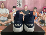 Rear view of navy blue Nike basketball sneakers showing heel pull tabs, textured heel panels, light-colored soles, and visible ZOOM text.