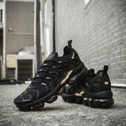 Black and gold Nike TN-11 sneakers arranged together