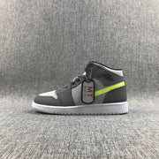 Side profile of one grey and charcoal mid-top sneaker with fluorescent accent and attached hangtag.