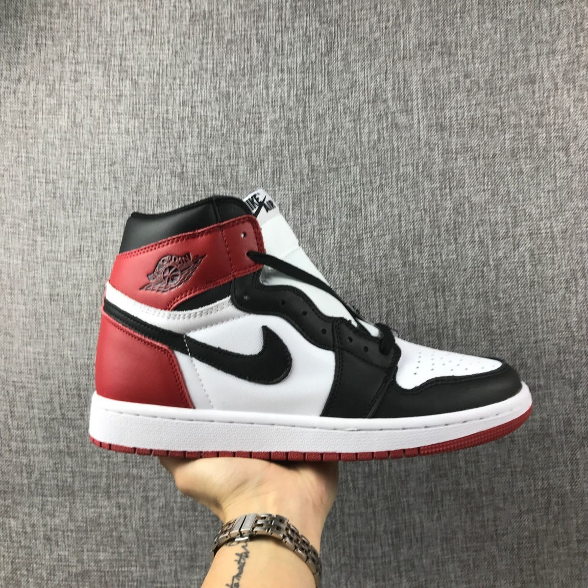 Side view of a black, white, and red Air Jordan 1 high-top sneaker