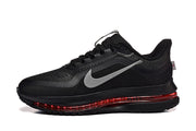 Side view of a black Nike Pegasus Premium shoe with gray Swoosh and translucent red sole accent.