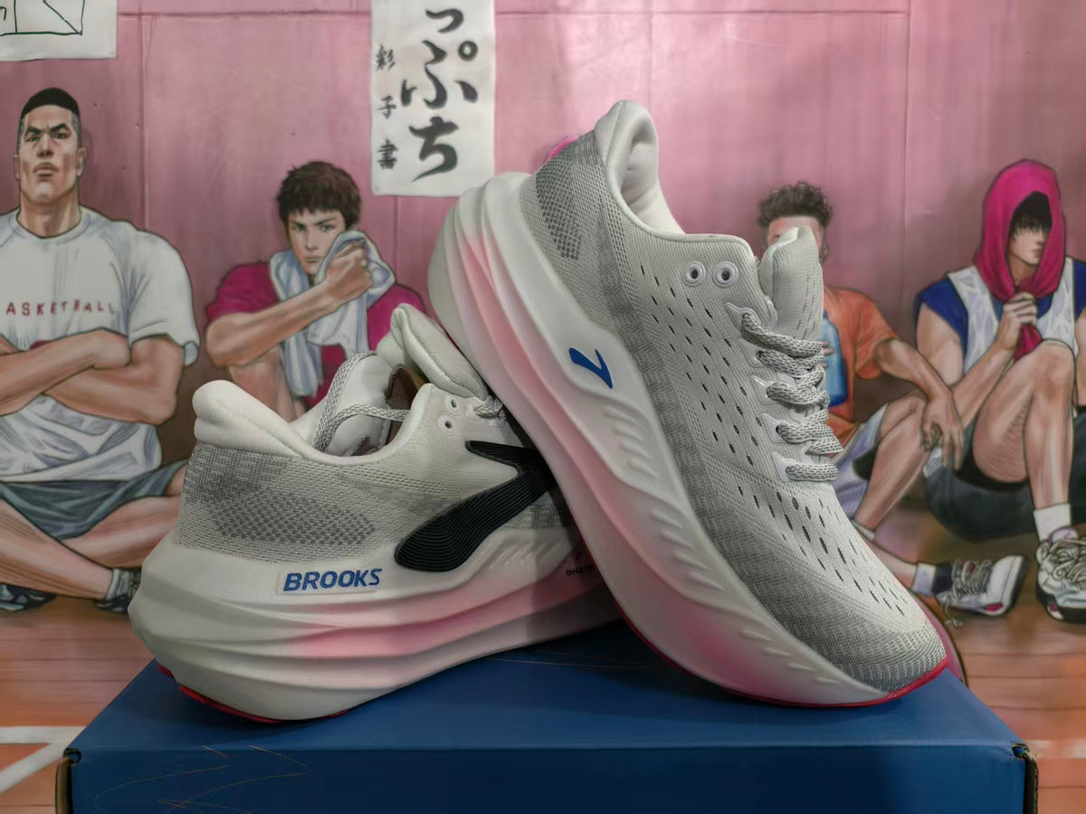 Pair of Brooks light gray-white running shoes with pink midsole accents, dark side logos, and red outsole details