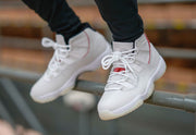 Worn three-quarter view highlighting the high-top shape and red side trim.