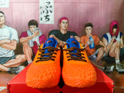 Pair of orange and blue Nike basketball-style sneakers shown from the front on a red shoebox.