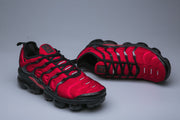 Pair of red and black Nike TN sneakers shown from front and side.