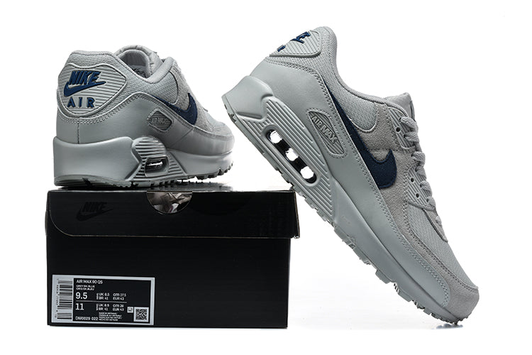 Grey and navy Nike Air Max 90 sneakers displayed with a shoe box; the box label shows a sample size.