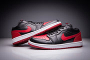 Pair of black and red low-top Jordan sneakers shown from the side on a studio background.