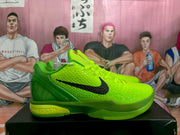 Side profile of a green Nike KD basketball sneaker showing the black Swoosh, textured upper, and layered sole.