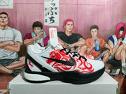 Side view of a white Nike basketball sneaker with red graphics, a black Swoosh, black sole sections, and a white midsole.