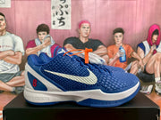 Side profile of a blue and white Nike basketball sneaker showing the textured upper, white Swoosh, red number 8 detail, and white midsole.
