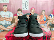 Front view of black basketball shoes with multiple wide straps and white outsoles.