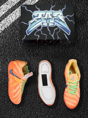 Top and side views of orange-red Nike sneakers with green laces, yellow accents, and a patterned upper.