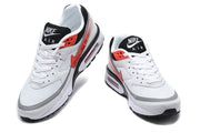 Front and angled views of white and red Nike Air Max sneakers