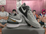 Pair of silver Nike basketball shoes displayed at an angle, showing contrasting side panels and textured outsoles