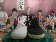 Front view of the mismatched pair showing white and black toe boxes, contrasting laces, red details, and textured uppers.