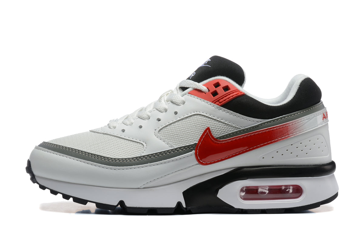 White and grey low-top sneaker with a red side Swoosh, black accents, and a visible heel cushioning unit