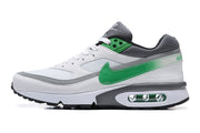 Side profile of a white sneaker with green accent, grey overlays, and a visible midsole air unit.
