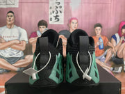 Rear view of the black-and-green Jordan sneakers showing the heel design, pull tabs, and contrasting side panels.