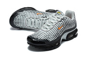 Angled top view of grey and black Nike Air Max Plus VII sneakers with orange Swoosh accents.