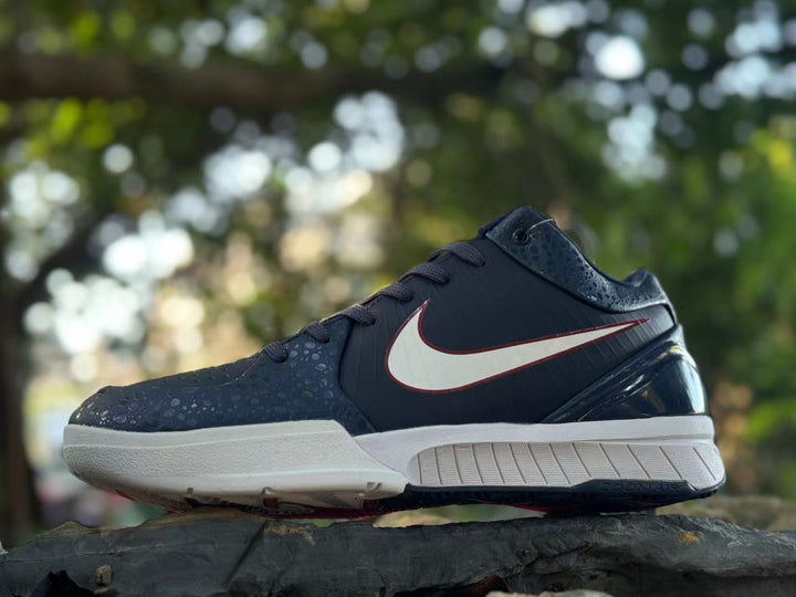 Side view of navy Nike Kobe 4 basketball shoe with white and red side logo and white midsole