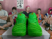 Front view of bright green lace-up basketball sneakers with textured uppers and patterned green toe outsoles.