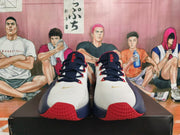Front view of white and navy Nike basketball shoes with red and gold accents