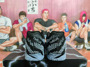 Rear view of black and gray Nike basketball shoes with patterned uppers and heel lettering reading TWELVE