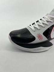 Angled view of the perforated black toe, white laces, and red accent marks