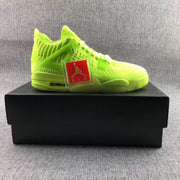 Side profile of a fluorescent green sneaker displayed on a black shoe box with a red Jordan hangtag.