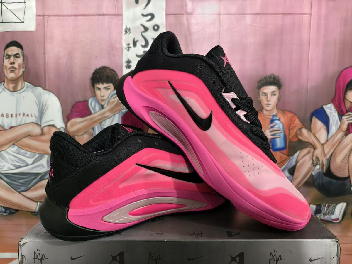 Pair of black and vivid pink sneakers shown from a three-quarter side angle on a shoebox.