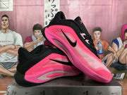 Pair of black and vivid pink sneakers shown from a three-quarter side angle on a shoebox.